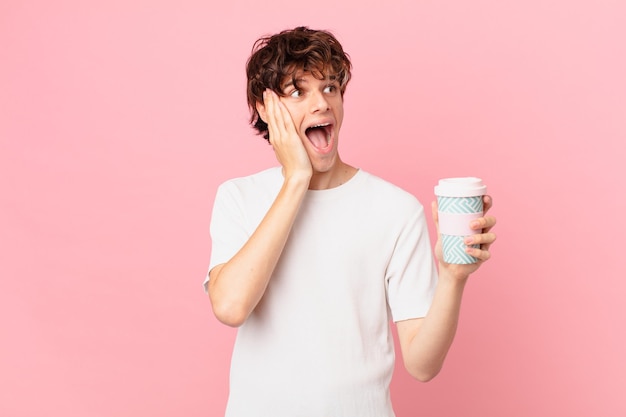 Young man with a coffee feeling happy, excited and surprised