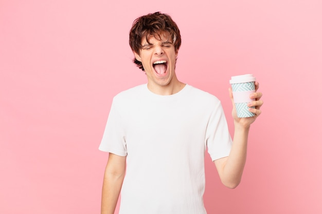 Young man with a coffee shouting aggressively, looking very angry