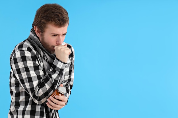 Young man with cold on blue background