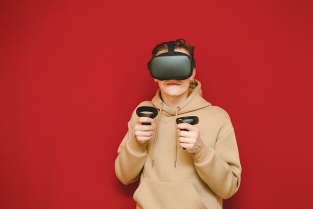 Young man with controller in his hands and VR helmet playing video games