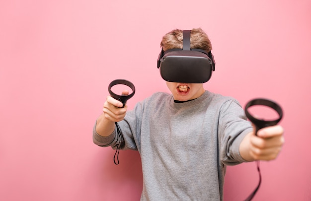 Young man with controller in his hands and VR helmet playing video games