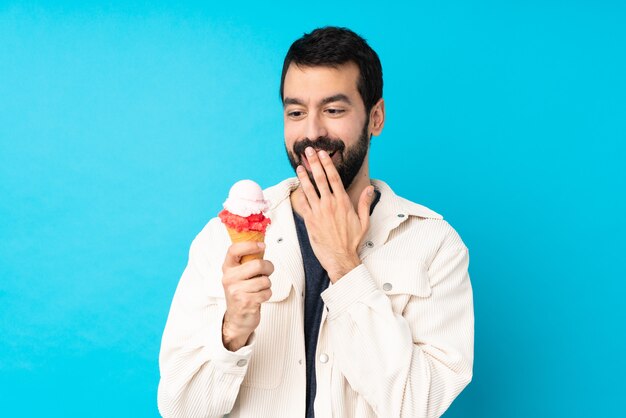 青の上のコルネットアイスクリームと若い男