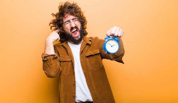 Young man with crazy hair in motion and an alarm clock