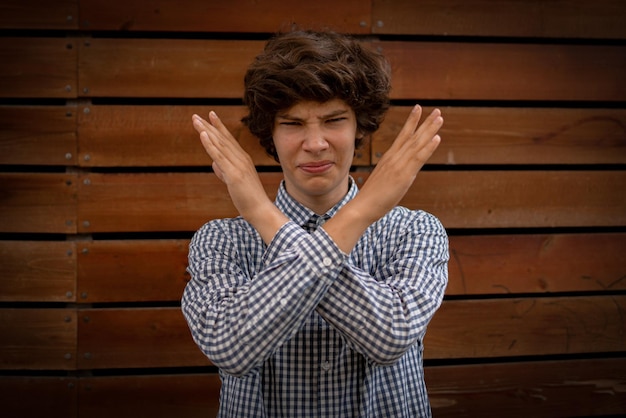 Young man with crossed hands in front of face stop gesture sign