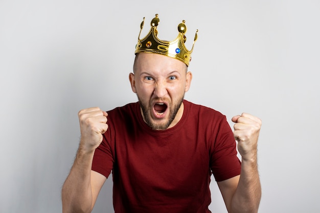 Young man with a crown on his head isolated