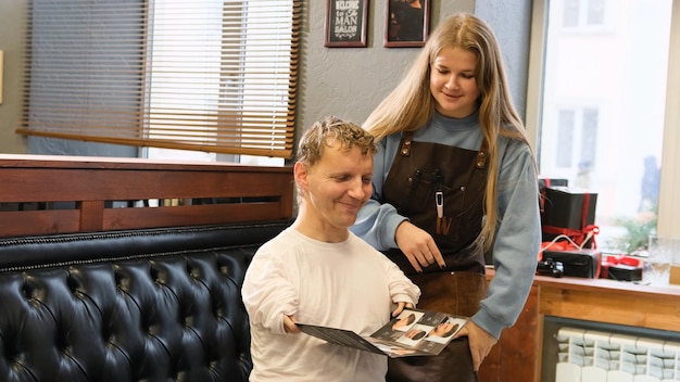 A young man with disabilities discusses a haircut with his master in a barbershop