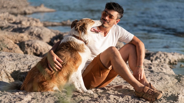 写真 海辺で犬と若い男