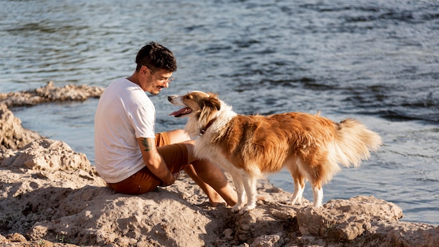 写真 海辺で犬と若い男