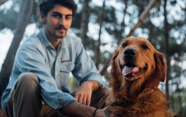 Photo young man with dog in forest