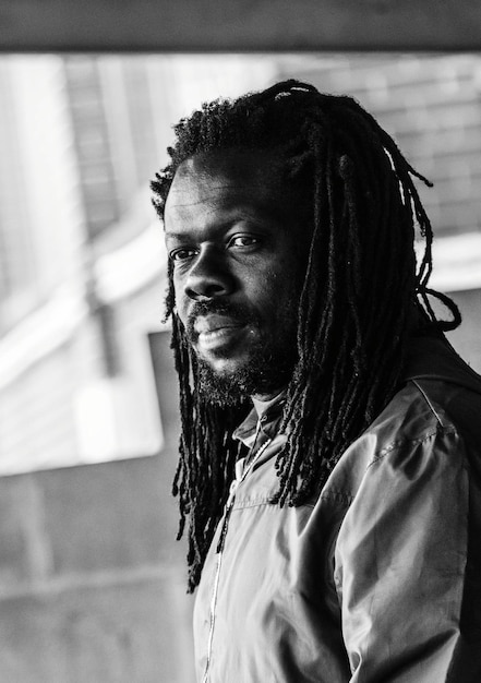 young man with dreadlocks looking away