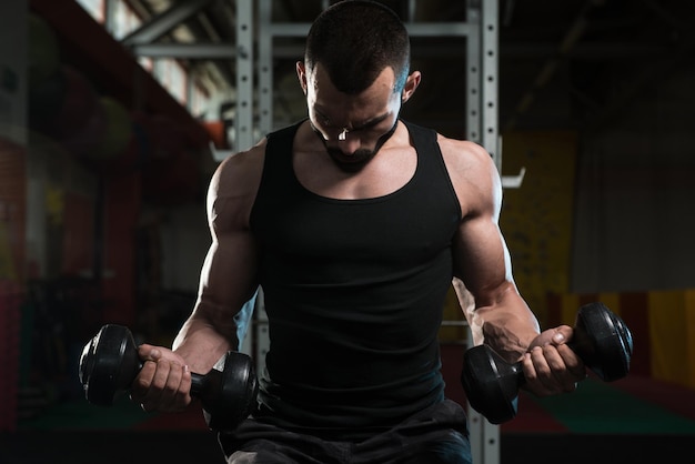 Young Man With Dumbbells Exercising Biceps