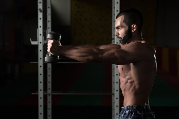 Young Man With Dumbbells Exercising Shoulders