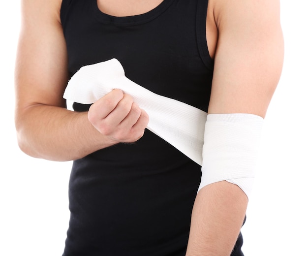 Young man with elastic bandage on hand isolated on white