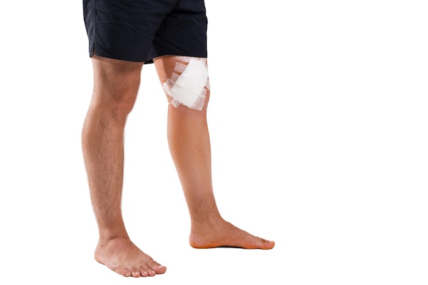 young man with elastic bandage on knee isolated on white