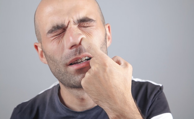 Young man with finger in his nose.