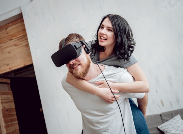 The young man with girlfriend playing games with virtual reality goggles