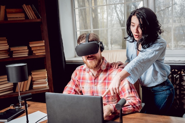 The young man with girlfriend plays a game at the office.