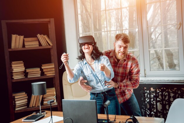 The young man with girlfriend plays a game at the office.