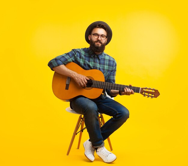Young man with guitar in studio
