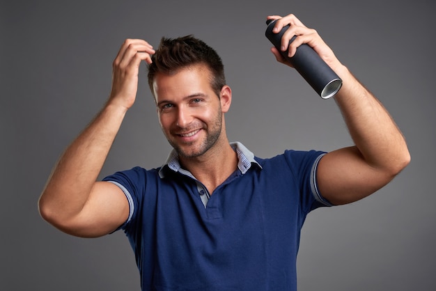 ヘアスプレーを持つ若い男