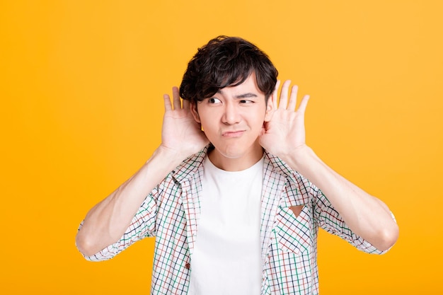 Young man with hand over ear listening and hearing