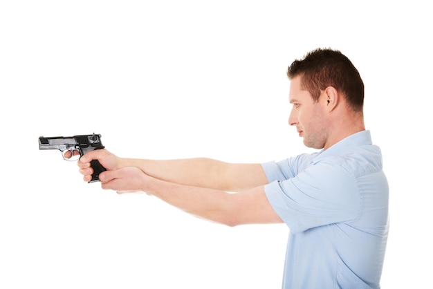 Young man with handgun against white background