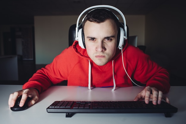Young man with headphones playing video games on the computer.