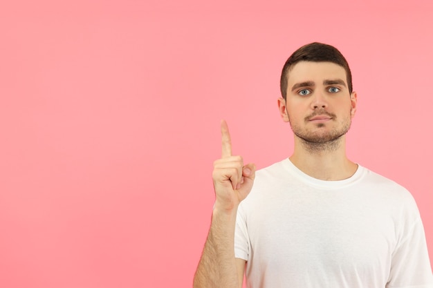 Young man with idea on pink background, space for text.