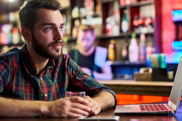 Young Man with Laptop in Bar