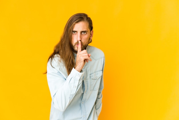 Young man with long hair look keeping a secret or asking for silence.