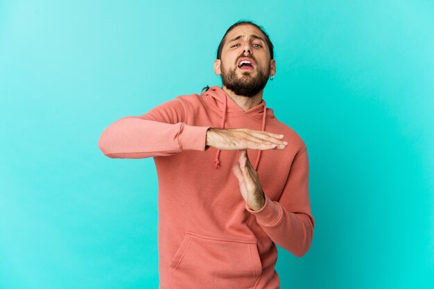 Young man with long hair look showing a timeout gesture.