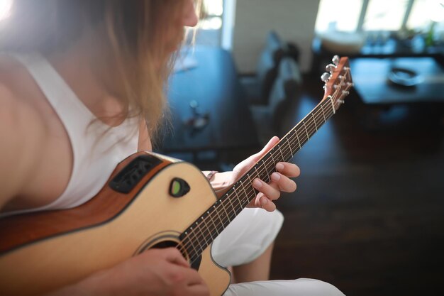 Giovane con i capelli lunghi con una chitarra acustica