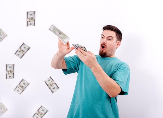 Young man with a lot of money is throwing the dollar bills