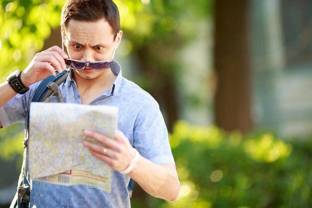 Photo young man with a map outdoors