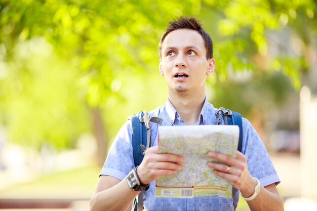 Young man with a map outdoors