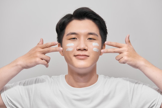 Young man with moisturizer on the face