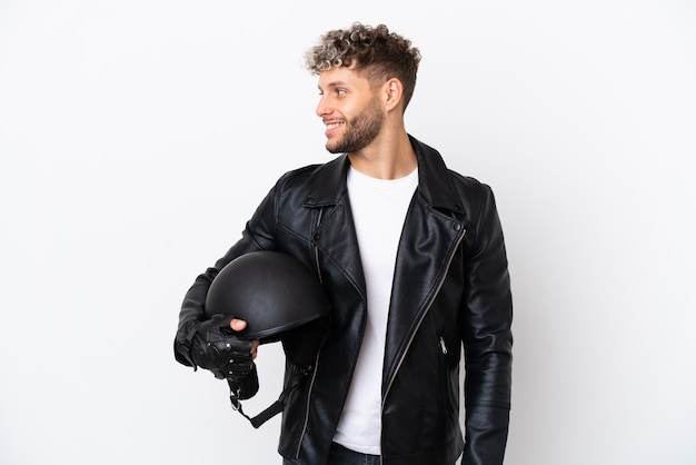 Young man with a motorcycle helmet isolated on white background looking side