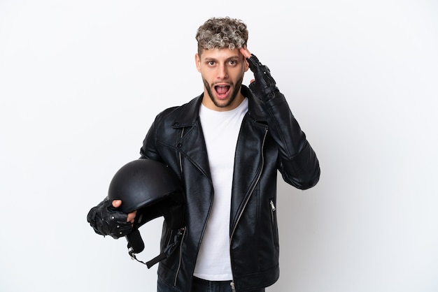 Young man with a motorcycle helmet isolated on white background with surprise expression