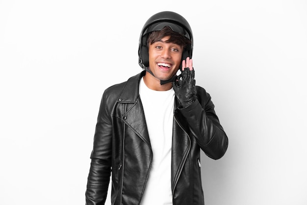 Young man with a motorcycle helmet isolated on white background with surprise and shocked facial expression