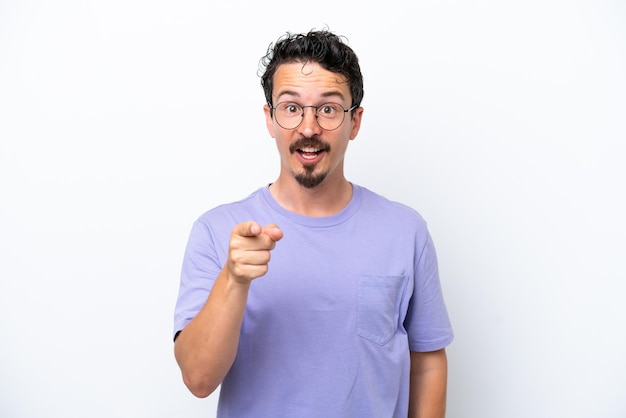 Young man with moustache isolated on white background surprised and pointing front