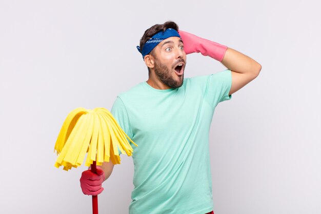 Young man with open mouth, looking horrified and shocked because of a terrible mistake, raising hands to head