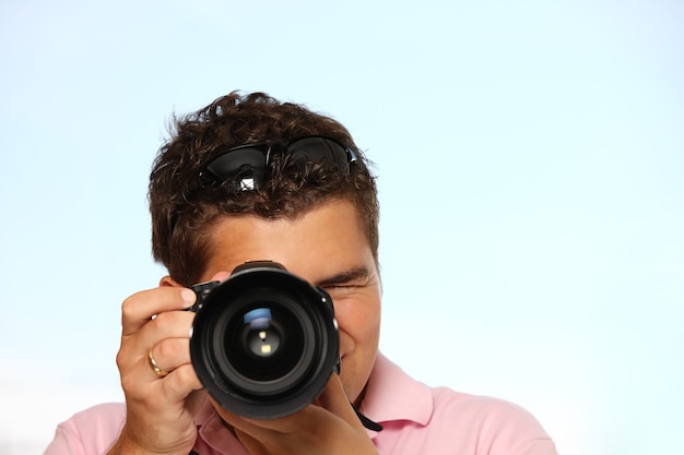 写真を撮る写真カメラを持つ若い男