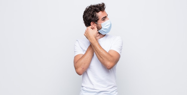 Young man with a  protective mask against white wall