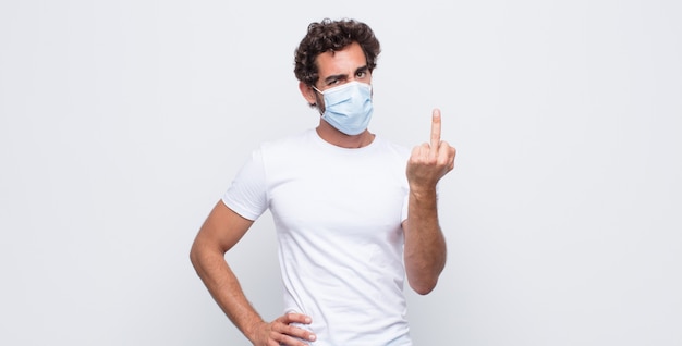 Young man with a  protective mask against white wall