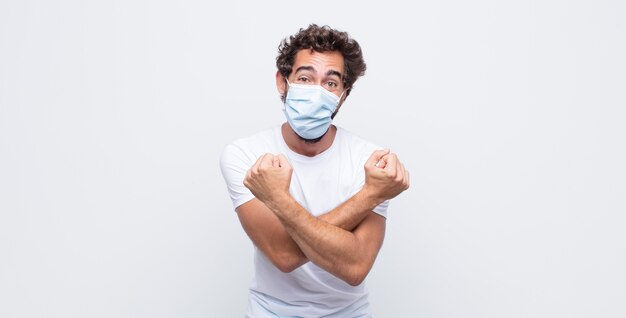 Young man with a  protective mask against white wall