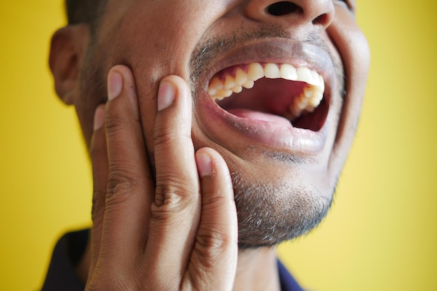 Young man with sensitive teeth close up