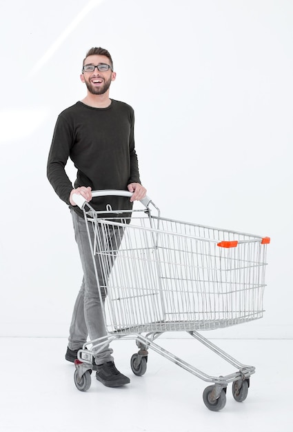 Young man with a shopping cart steps forward