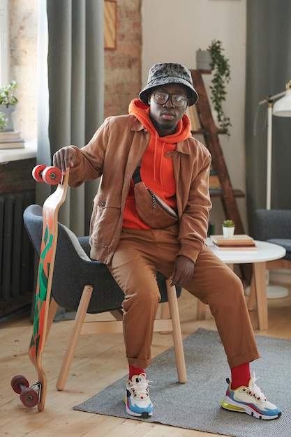 Young Man With Skateboard In Living Room