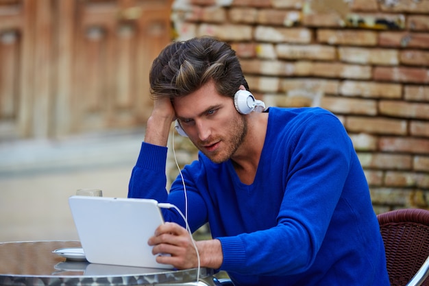 タブレットpcを持つ若者がカフェで触れる