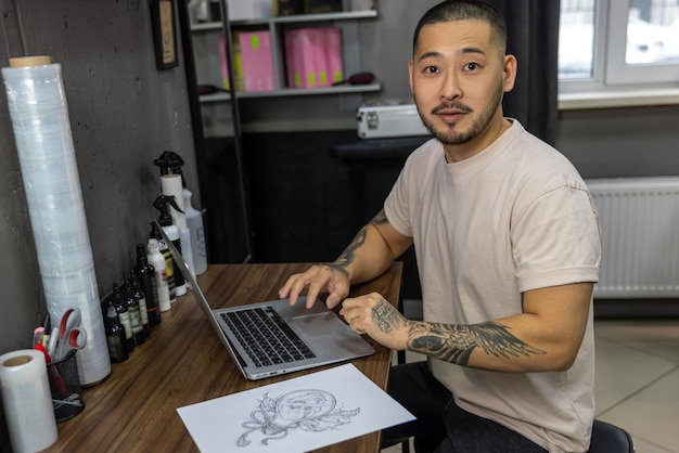 Young man with tattoos working on laptop